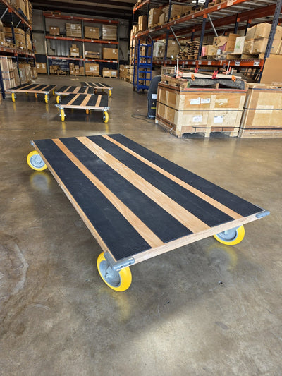 Solo CasterHQ kiln-dried oak platform cart with yellow casters and black conveyor-belt grip strips in Mansfield Texas warehouse