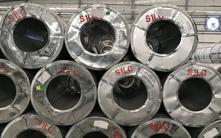 Rolled steel coils in a warehouse. The product whose Canada border tax rose to 50 percent on September 8, 2026.