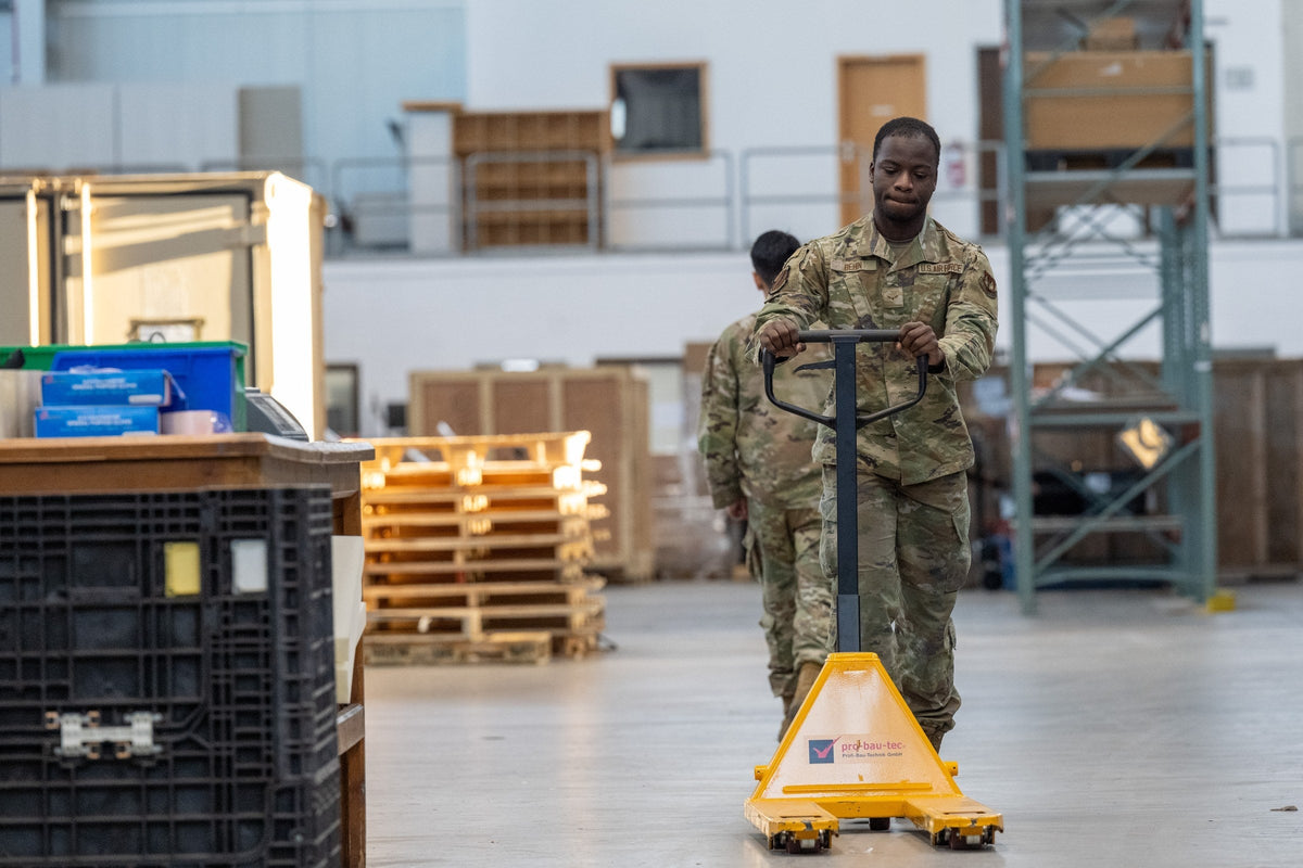 U.S. Air Force airman with yellow pallet jack in a logistics warehouse — illustrative material-handling duty context (USAF / public domain)