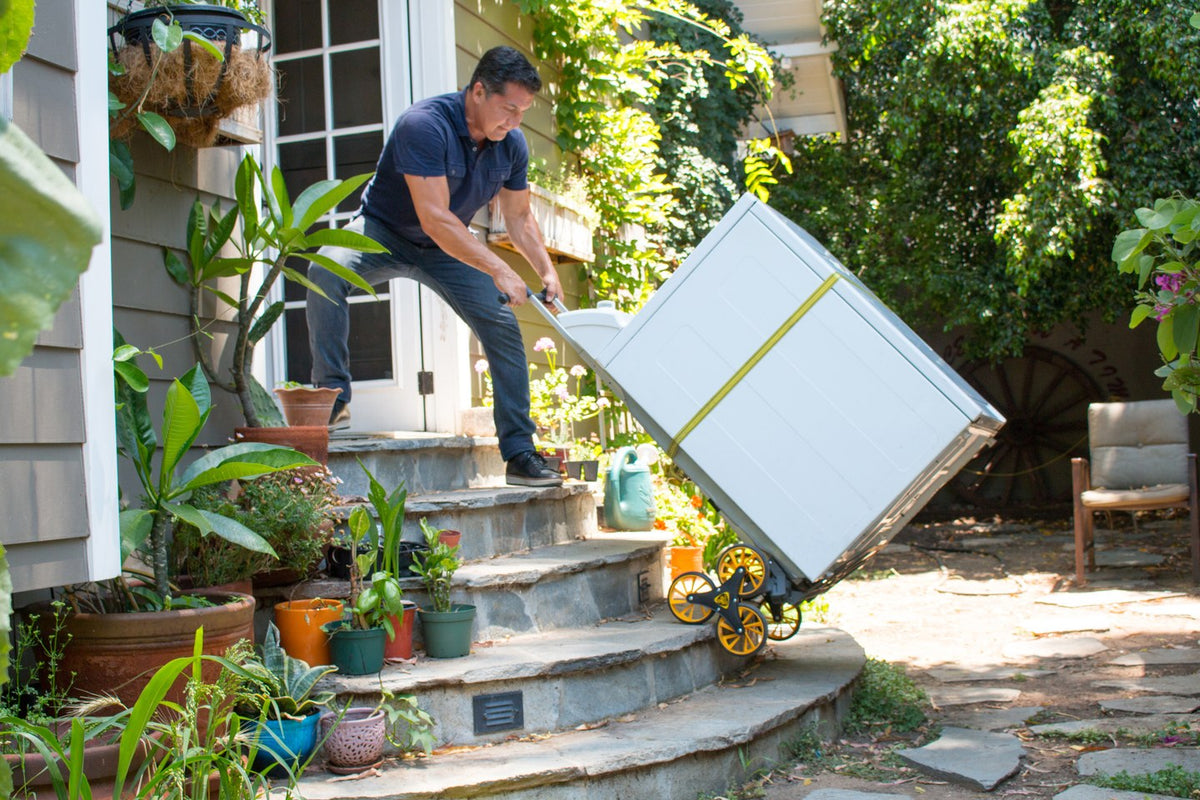 Stair-climbing hand truck moving an appliance on outdoor steps, illustrative of a hand truck type, not AD case merchandise