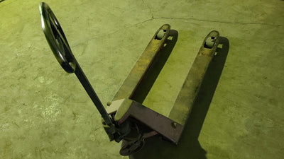 Manually propelled pallet jack on a concrete floor, illustrative of a low-lift type, not an ITSDF test